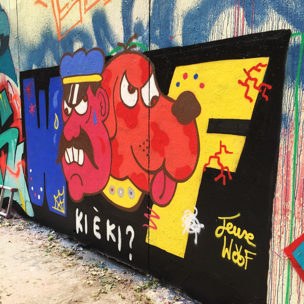 Colorful graffiti on a wall featuring a sailor and dog and vibrant patterns in the background.