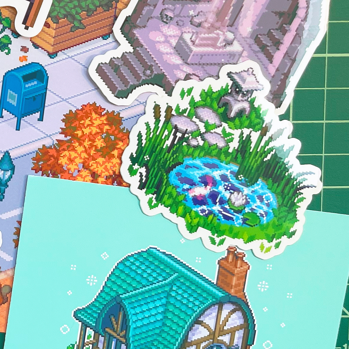 vinyl die cut and square pixel art stickers laying on cutting board