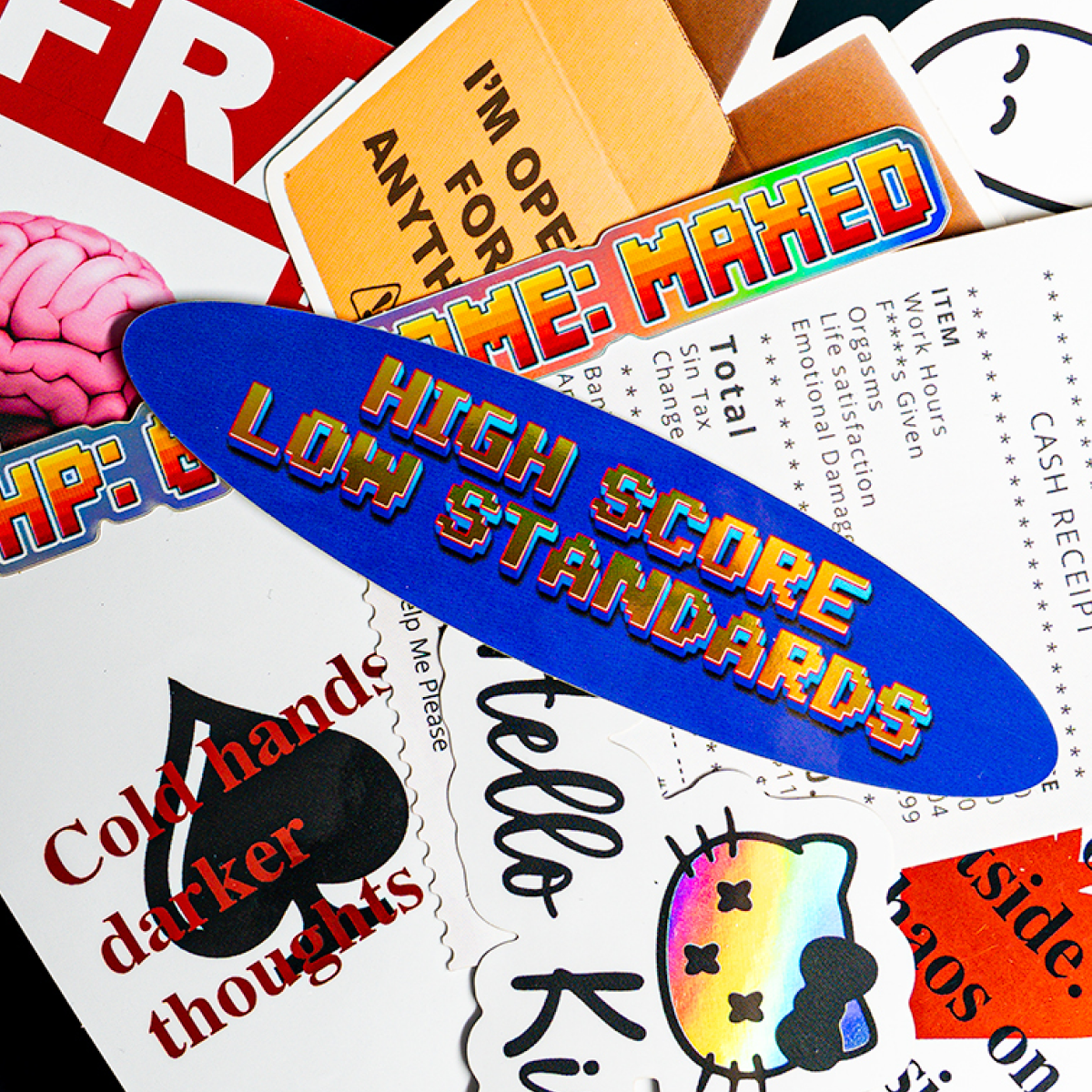 Stapel NSFW-stickers, waaronder een blauw ovaal "High score, low standards", een "Hello Kinky"-kat en speelkaartontwerpen
