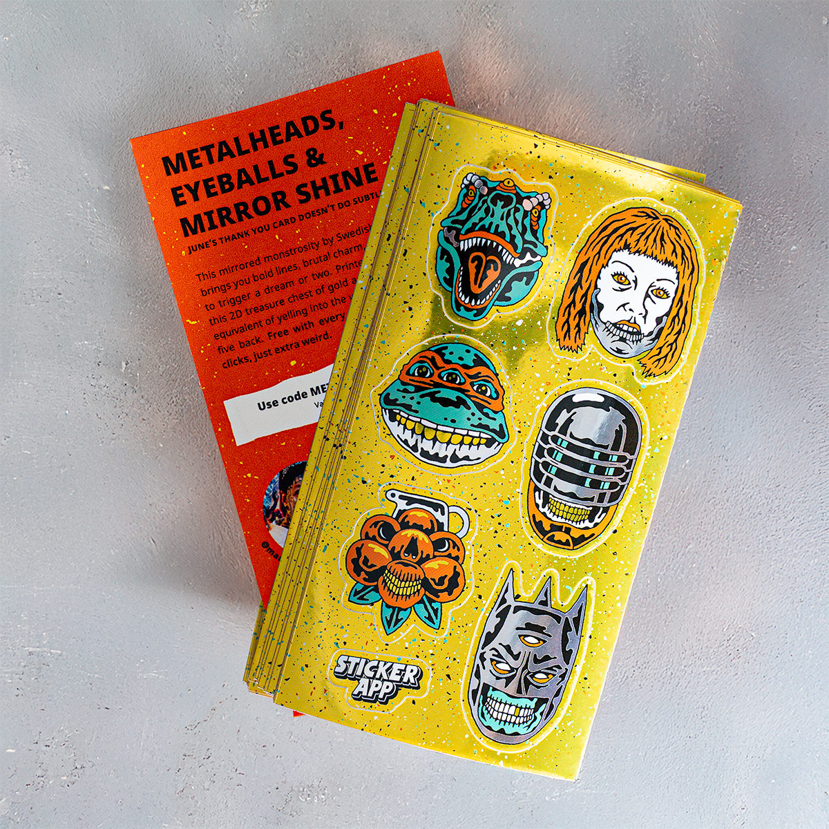 Golden custom sticker sheet printed on glossy mirror, with designs showing monsters, dinosaurs, and aliens, with an orange back paper print.