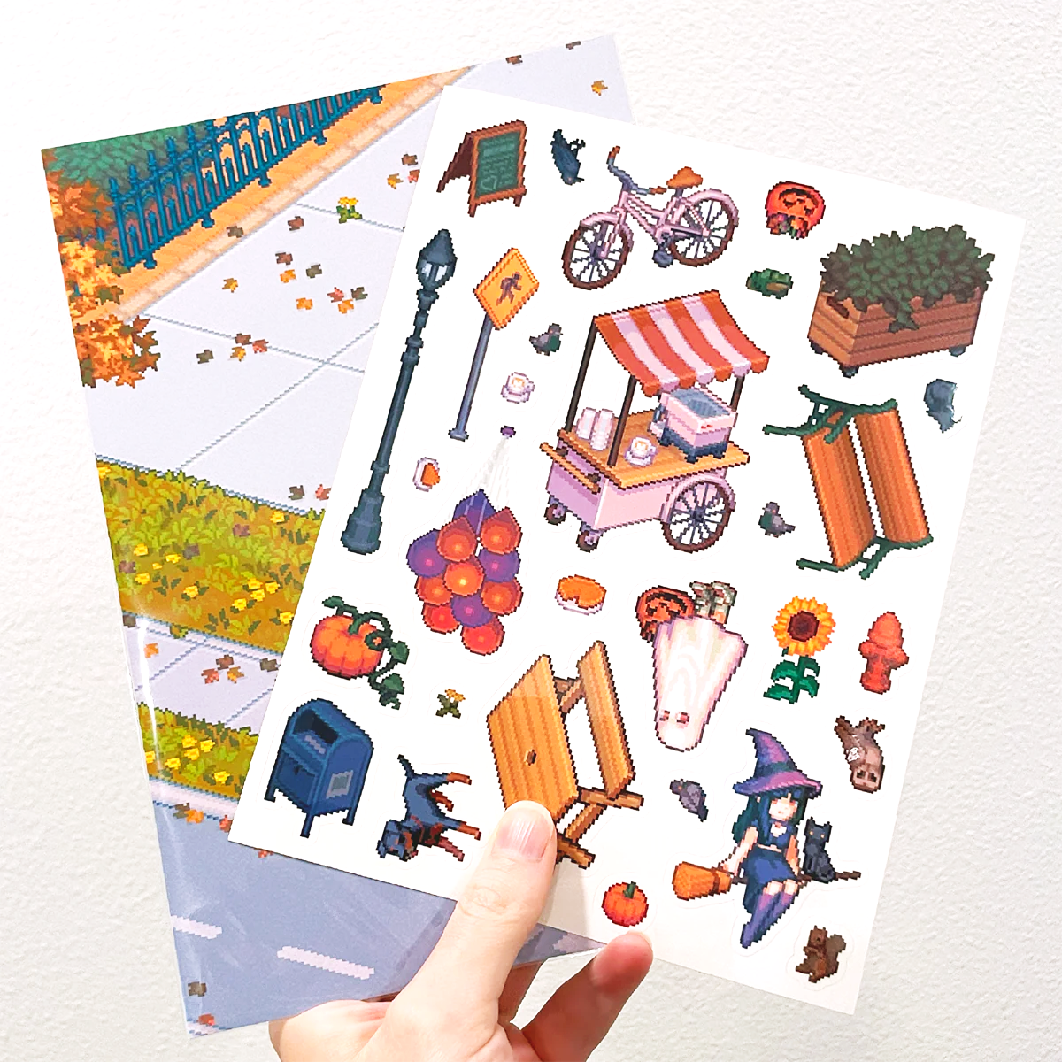 Person holding a transparent halloween sticker sheet with pixel art decoration