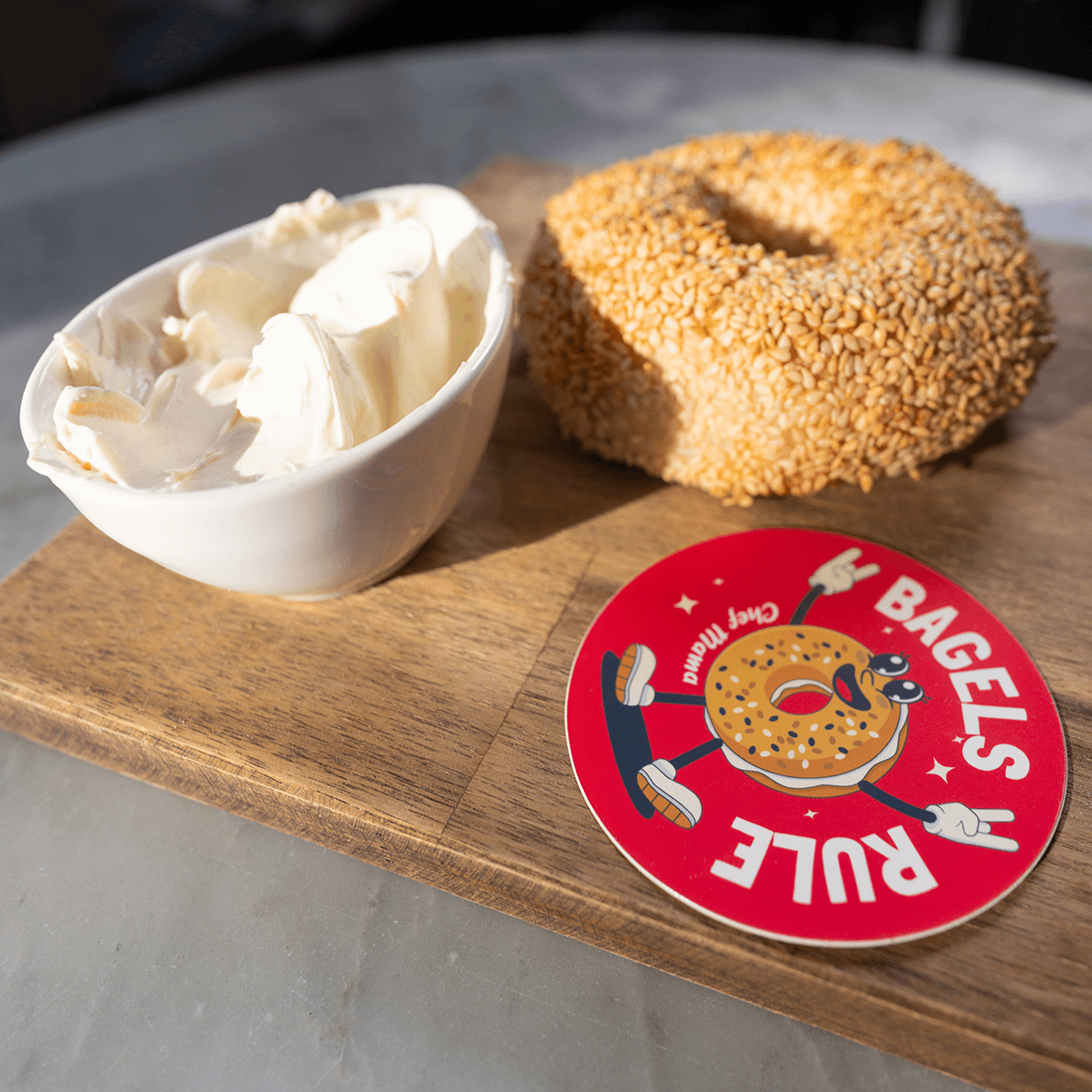 die cut sticker laying on table with bagel and cream cheese