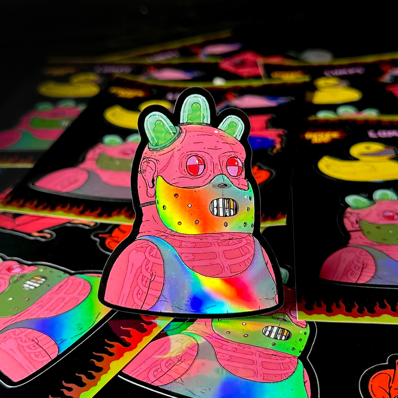 Colorful holographic sticker from a sticker sheet, with surrounding sticker sheets in the background