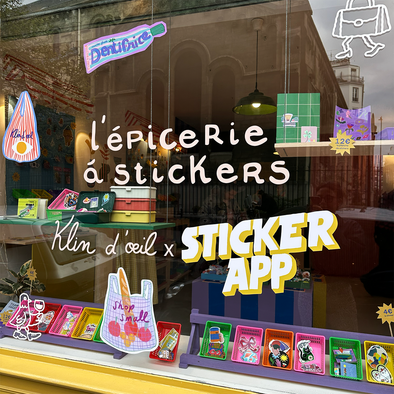 Storefront with colorful sticker-themed decorations and products displayed. Store name "l'épicerie à stickers" visible on the window.