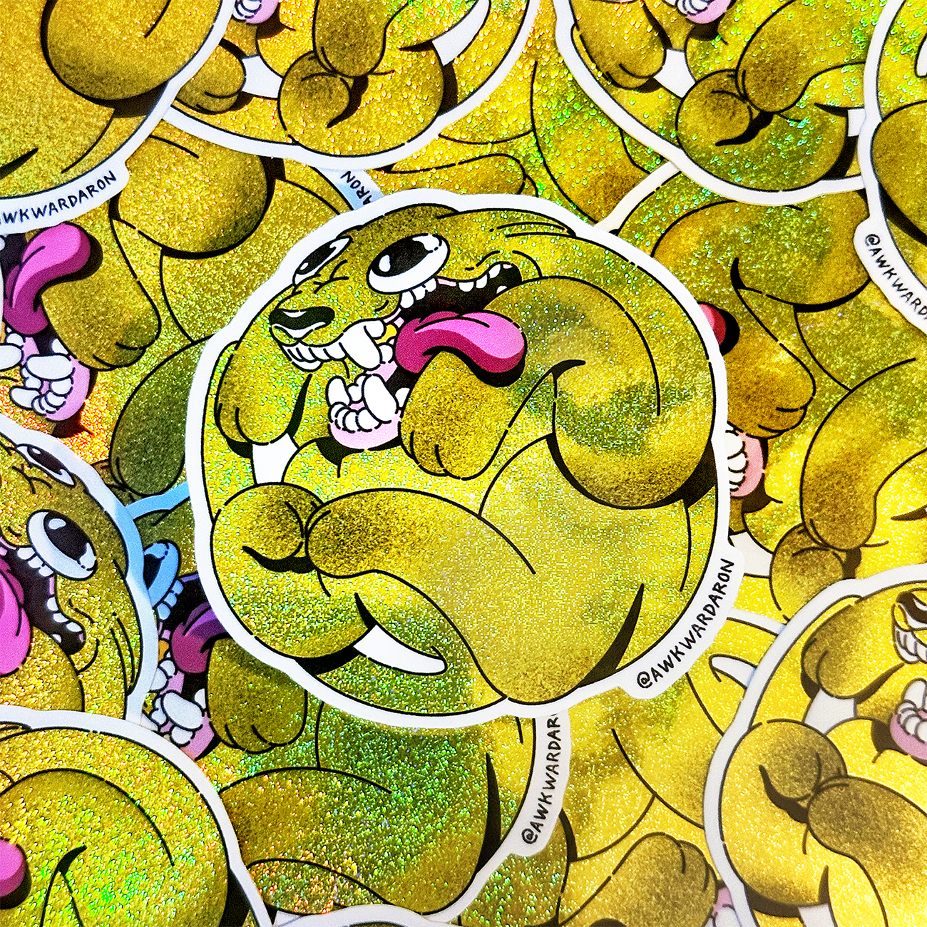 Yellow Pixie Dust cartoon dog in yellow, printed as a die-cut sticker on Pixie Dust, with several sticker laying flat in the background.