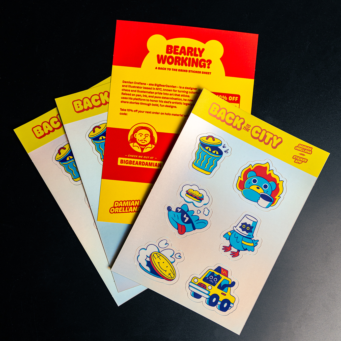 Colorful Bigbeardamian sticker sheets featuring cartoon animals and objects, alongside a promotional flyer with bold red and yellow text.