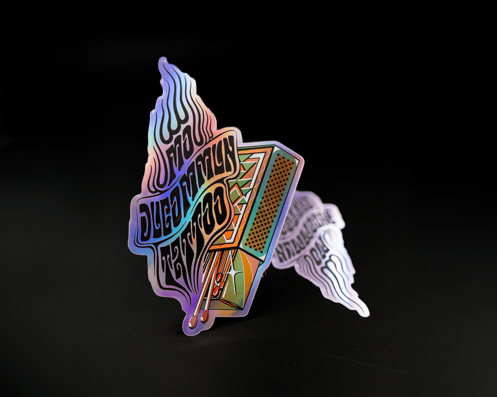 Holographic sticker with abstract design and text, featuring geometric shapes and vibrant colors on a dark background.