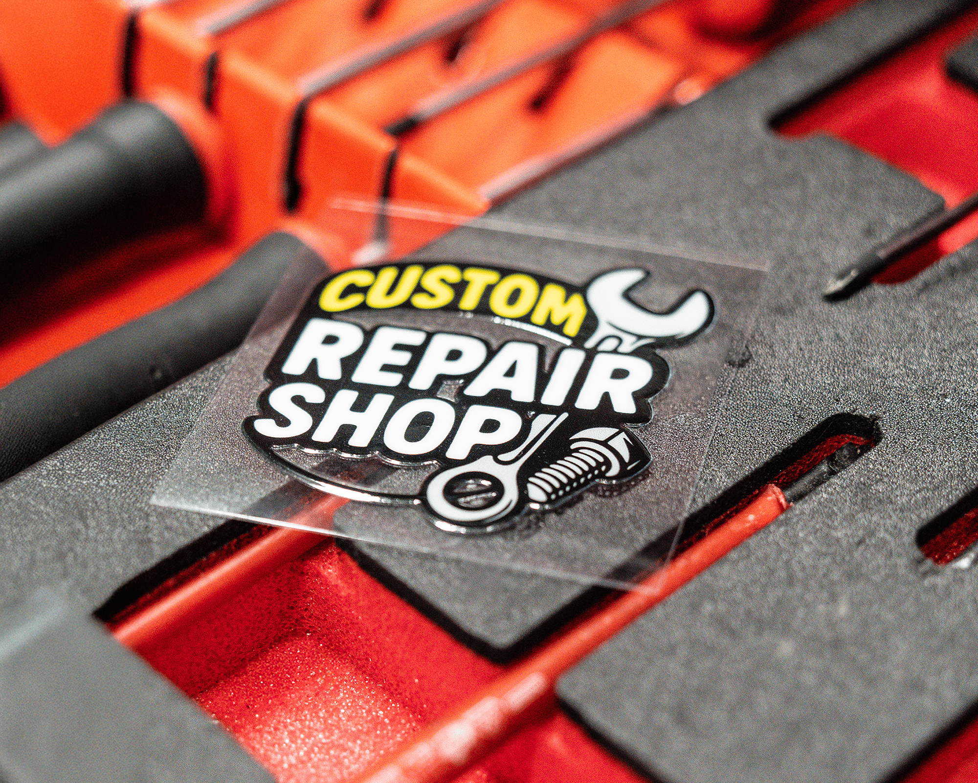 A transfer sticker reading "Custom Repair Shop" with a wrench and bolt design on a red and black textured background.