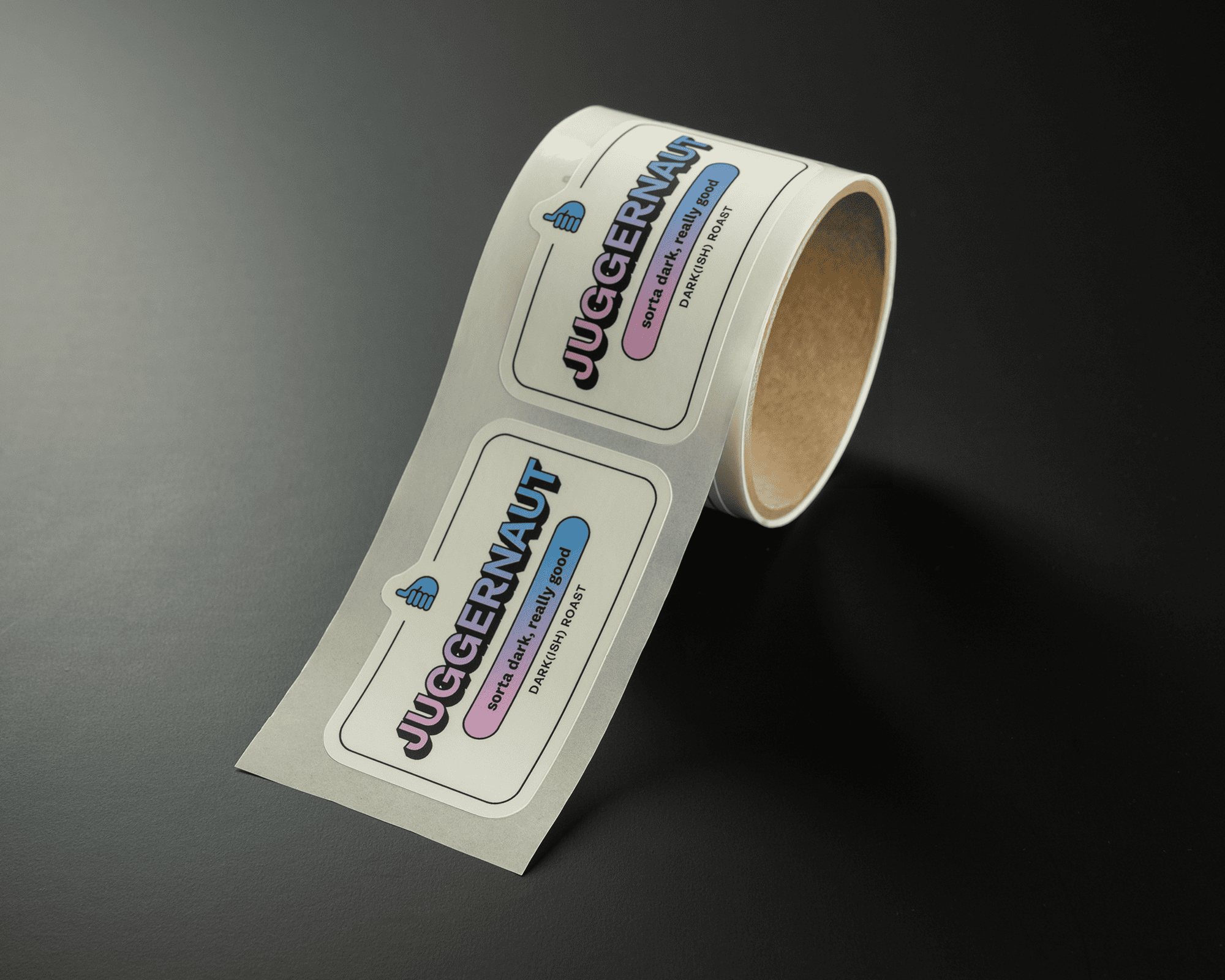 A roll of labels with the text "JUGGERNAUT" in bold, colorful letters on a dark surface.