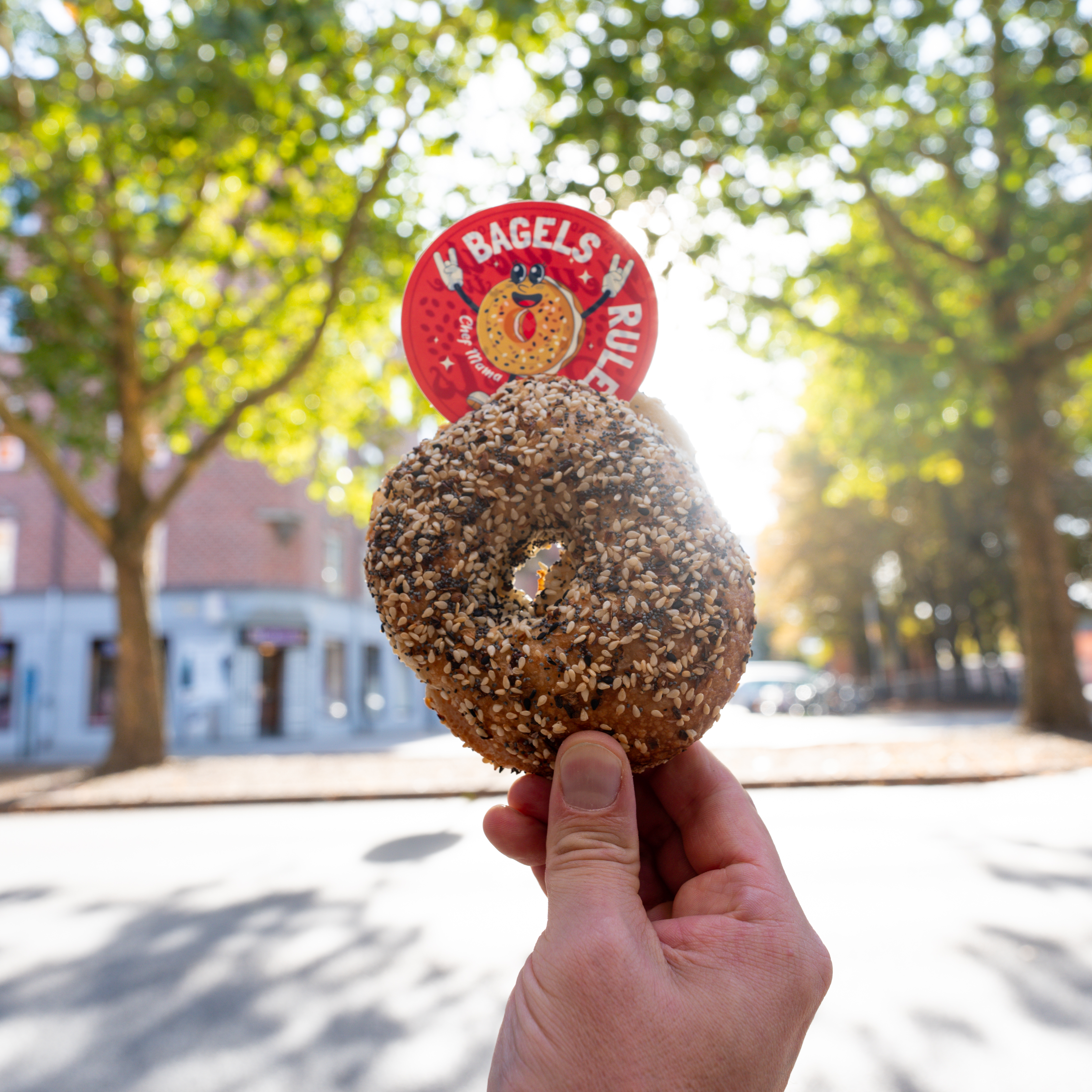 person holding up a die cut sticker and a donut in the air