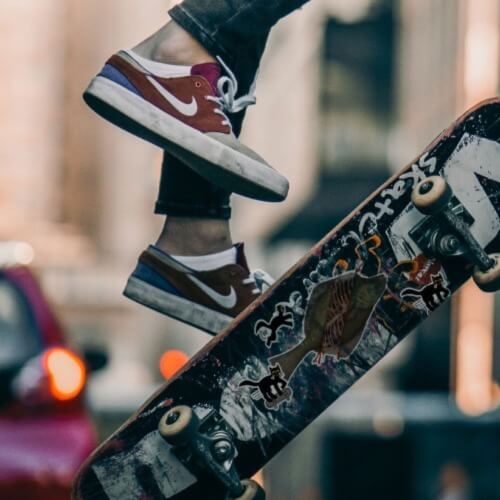 Flip side skateboard in the air with stickers beneath.