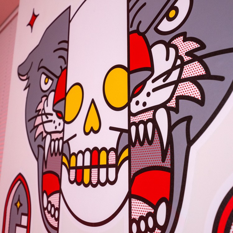 A close up of a wall sticker with a skull and a cat animal on it.