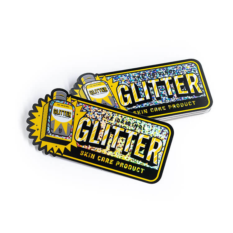 Two yellow and black glitter stickers on a white surface