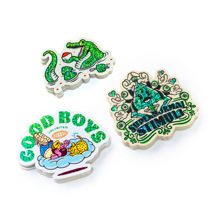 Stapels contourgesneden glitterstickers met een alligator, een "Good Boys"-logo en een "Supernormal Stimuli"-ontwerp